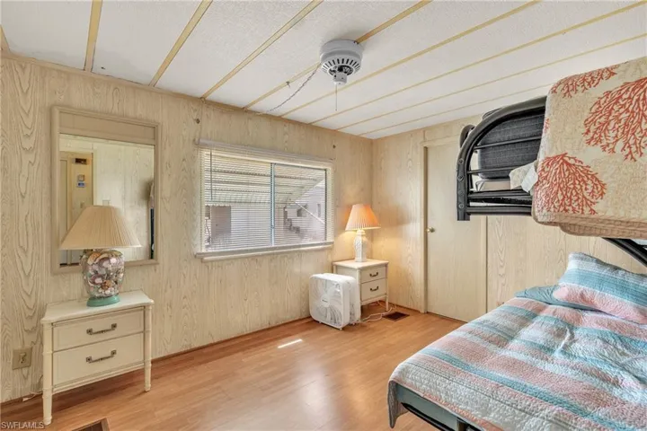 Bedroom featuring wood finished floors and wood walls
