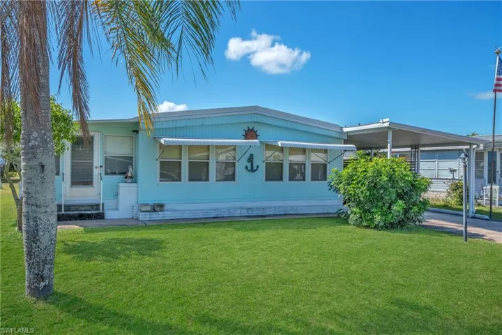 View of front of house with a carport and a front yard