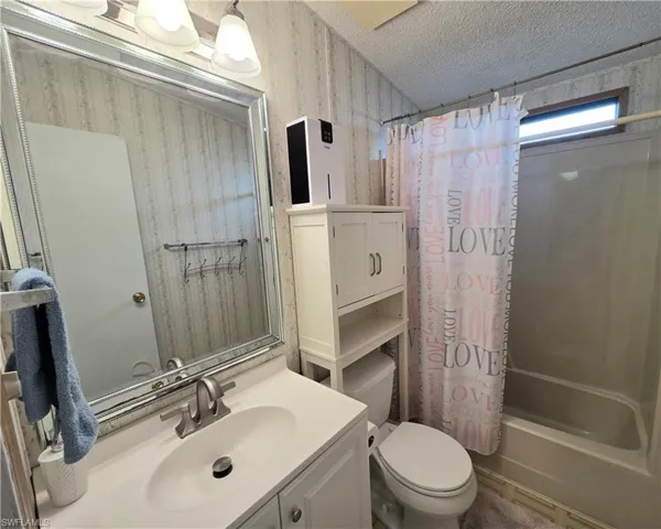 Bathroom featuring a single vanity with an integrated sink, brushed nickel faucet, and a large framed mirror