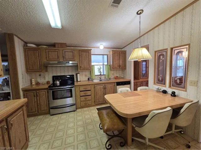 Spacious Kitchen with wood-finish cabinetry, stainless steel range, and dishwasher.