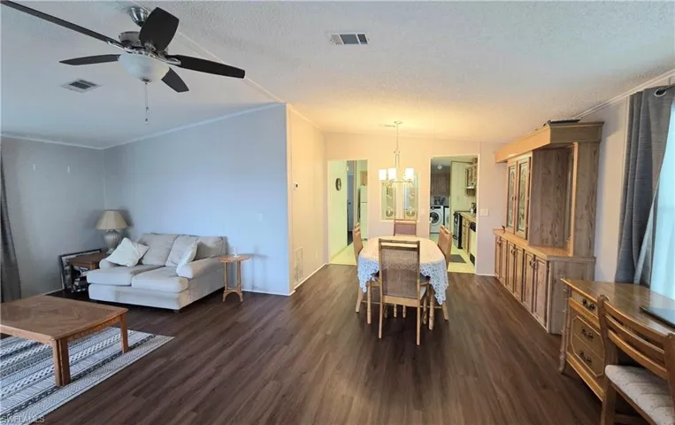 Open-concept living and dining area featuring  wood-finish flooring and ceiling fan.