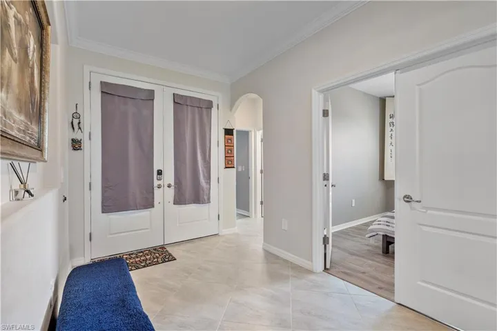 Entryway featuring light hardwood / wood-style floors, ornamental molding, and french doors