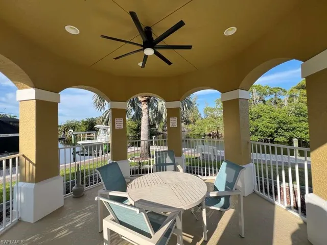Covered patio featuring an arched design and a ceiling fan with integrated lighting