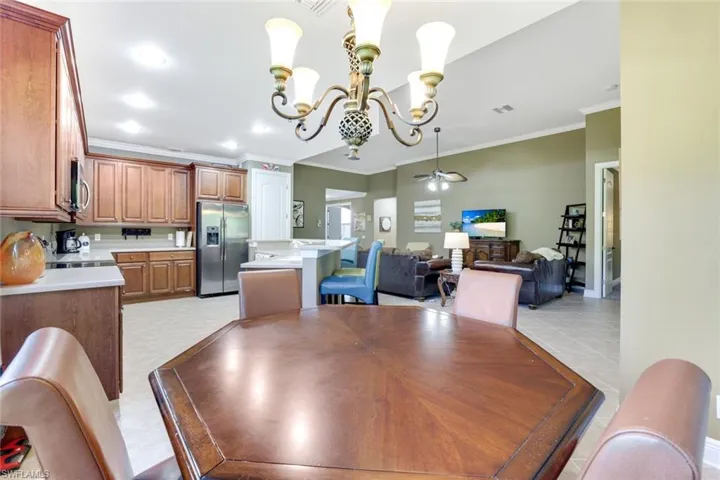 Dining area featuring crown molding, a chandelier, a ceiling fan, and recessed lighting