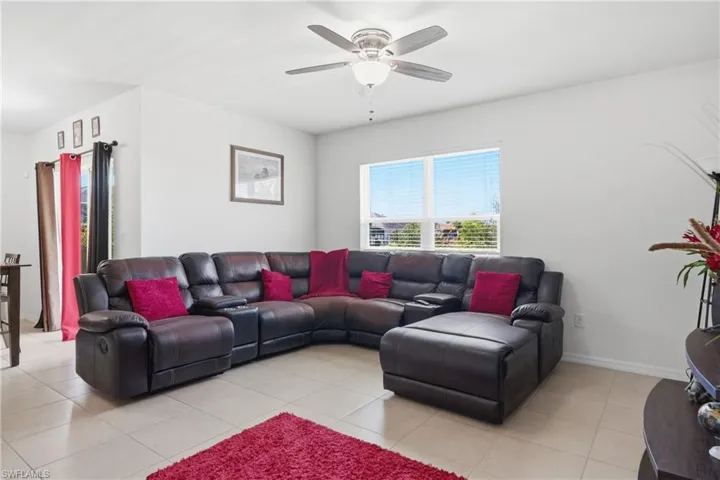 Living room with ceiling fan and light tile patterned floors