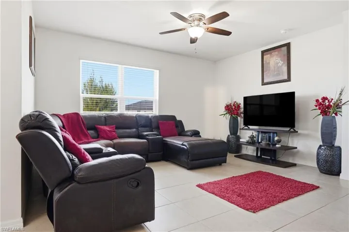 Living room with ceiling fan and light tile patterned floors