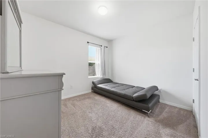 Bedroom with light colored carpet and baseboards