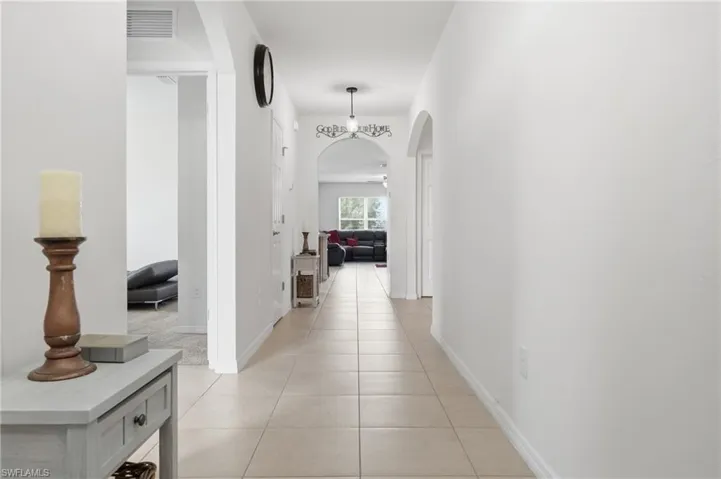Hall with arched walkways and light tile patterned floors