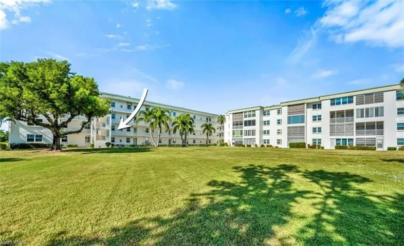 The property features extensive manicured lawns and mature trees