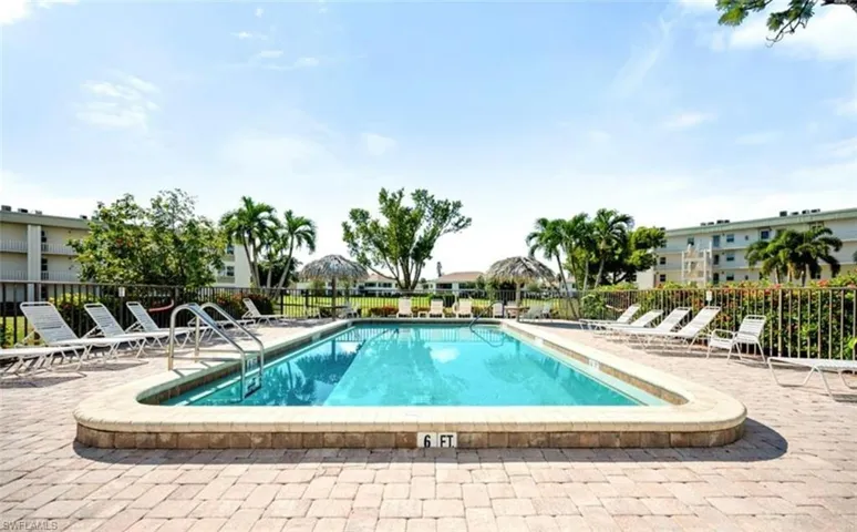 The property features an outdoor swimming pool surrounded by a paver patio and lounge chairs