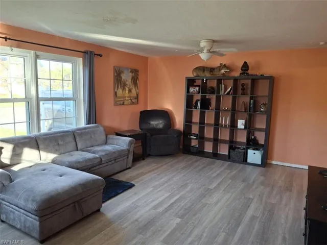 Living room featuring wood-type flooring and ceiling fan