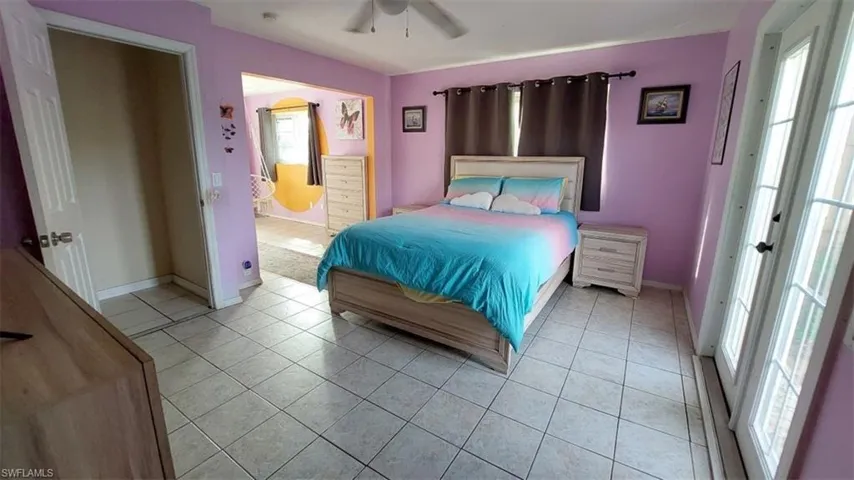 Bedroom with ceiling fan and light tile patterned floors