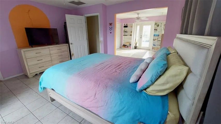 Tiled bedroom featuring french doors
