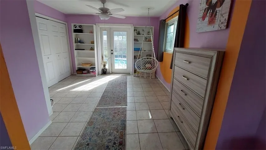 Doorway to outside with light tile patterned floors and ceiling fan
