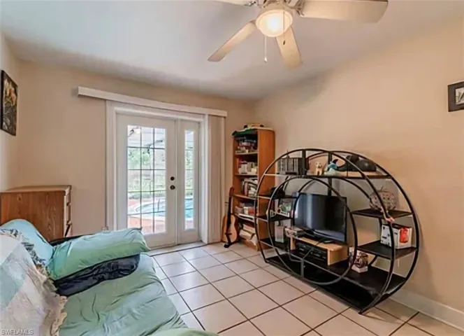 Bedroom with light tile patterned floors, access to exterior, ceiling fan, and french doors