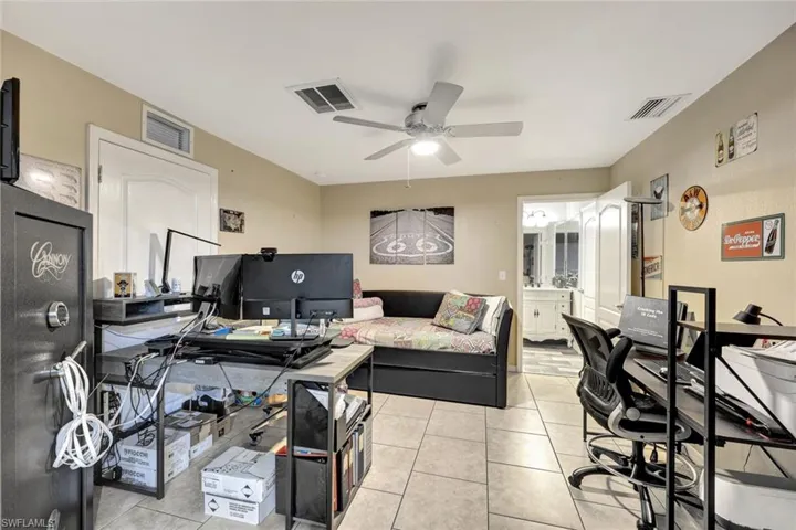 Office space with a ceiling fan and light tile patterned floors