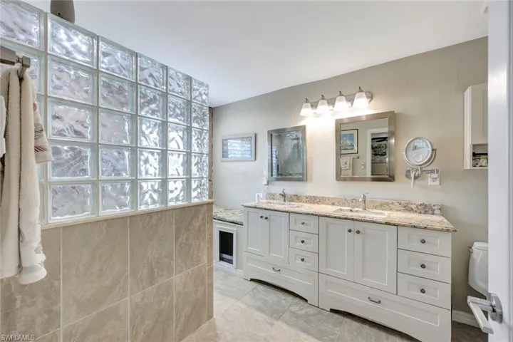 Full bathroom with toilet and double vanity
