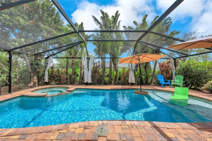 View of swimming pool with a pool with connected hot tub, a lanai, and a patio