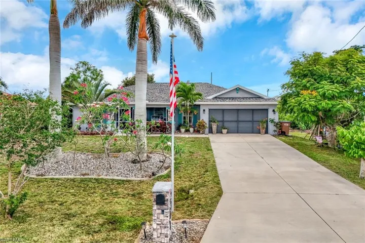 Ranch-style home featuring a front yard, an attached garage, concrete driveway, a shingled roof, and stucco siding
