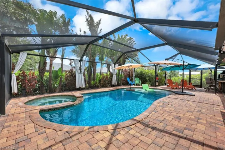View of pool featuring a patio, a pool with connected hot tub, a lanai, and outdoor dining space