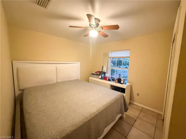 Bedroom featuring a ceiling fan, light tile patterned floors, and a closet