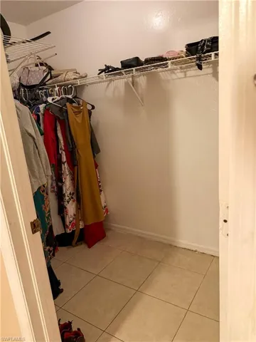 Walk in closet with light tile patterned floors