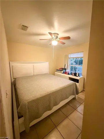 Bedroom featuring light tile patterned floors and a ceiling fan