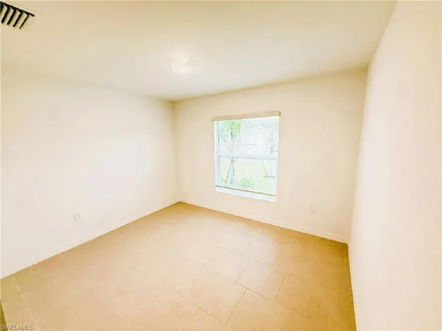 Empty room featuring baseboards and light tile patterned floors