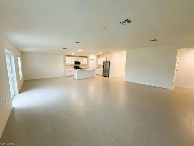 Unfurnished living room featuring baseboards and recessed lighting