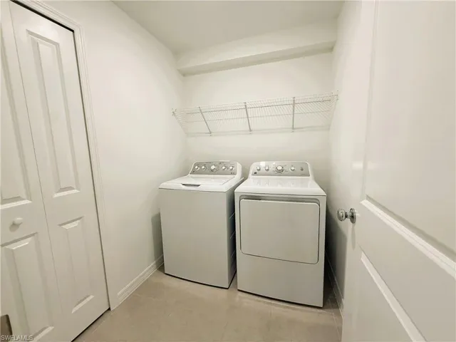 Laundry room featuring separate washer and dryer and baseboards