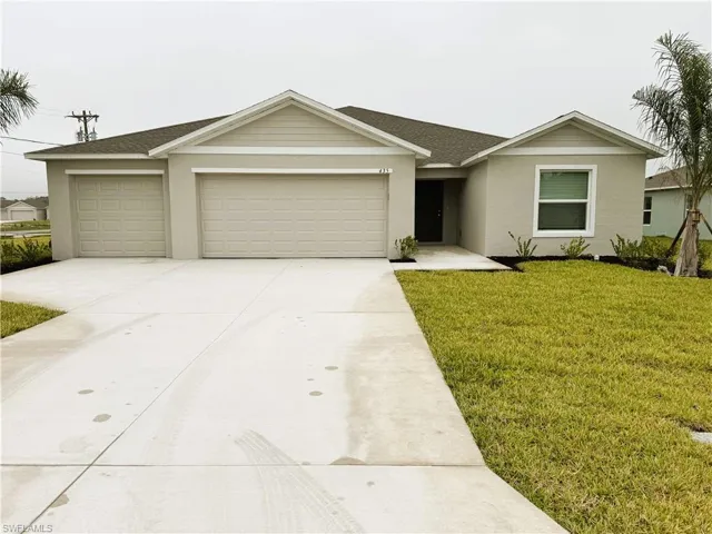 Single story home featuring a front yard, a garage, driveway, and roof with shingles