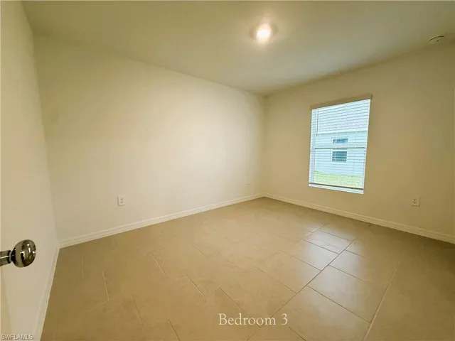 Spare room featuring baseboards and light tile patterned floors