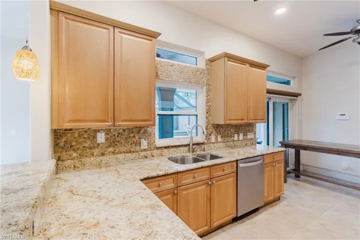 Kitchen featuring tasteful backsplash, stainless steel dishwasher, a sink, and a ceiling fan