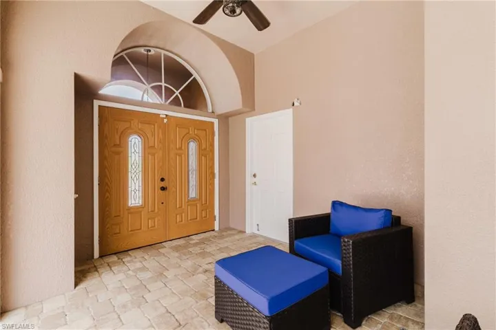 Entrance foyer featuring a ceiling fan, lofted ceiling, and stone finish flooring