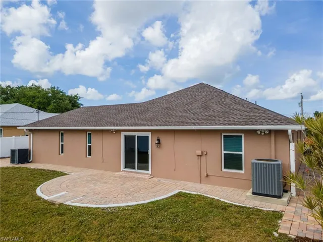 Back of property featuring central AC unit, a yard, a patio, and stucco siding