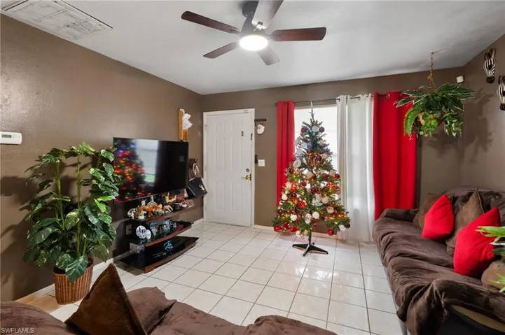 Living room featuring ceiling fan and light tile patterned flooring