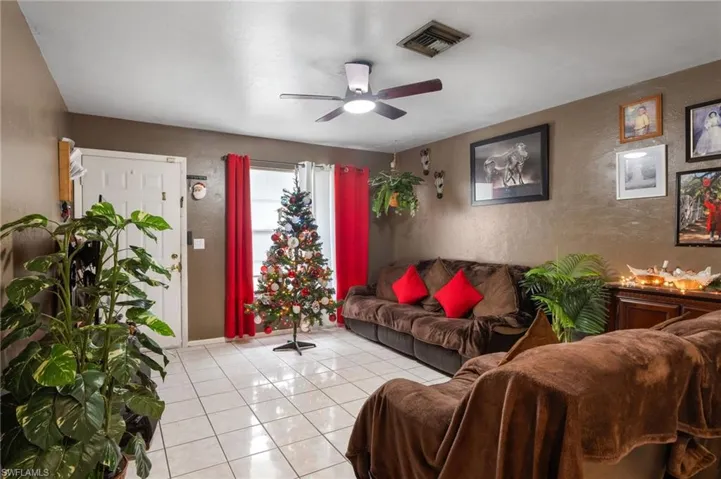 Living room with ceiling fan and light tile patterned floors