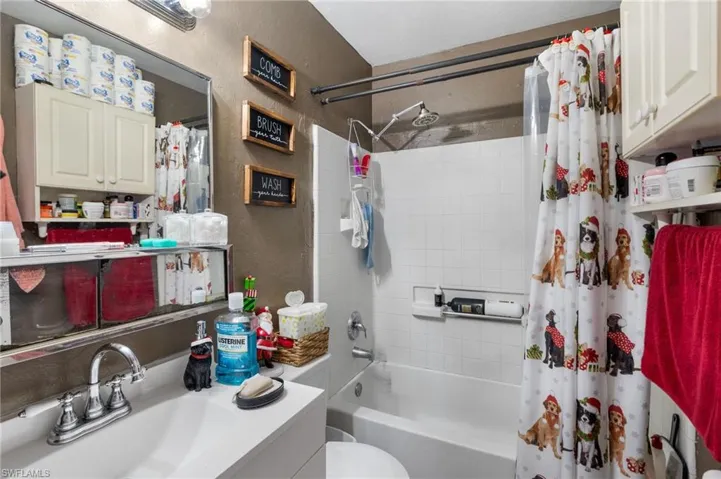 Full bathroom with toilet, shower / tub combo, and vanity