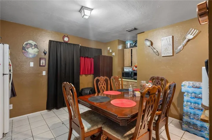 Dining space with light tile patterned floors and a textured ceiling