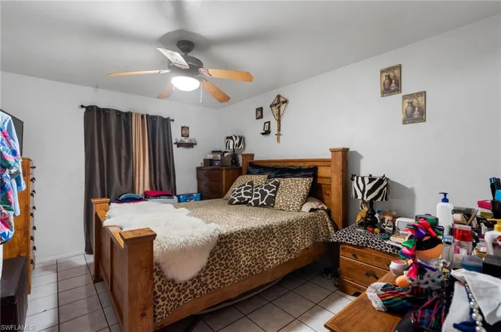 Tiled bedroom featuring ceiling fan