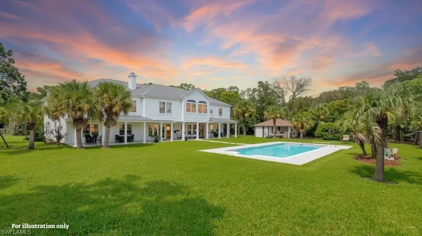 Back of property at dusk with a patio area, a yard, an outdoor pool, and a chimney