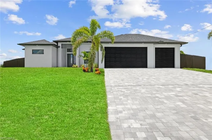 View of front of house with a garage and a front lawn