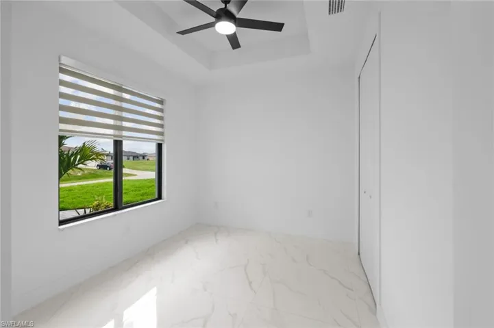 Empty room featuring light tile patterned floors and ceiling fan