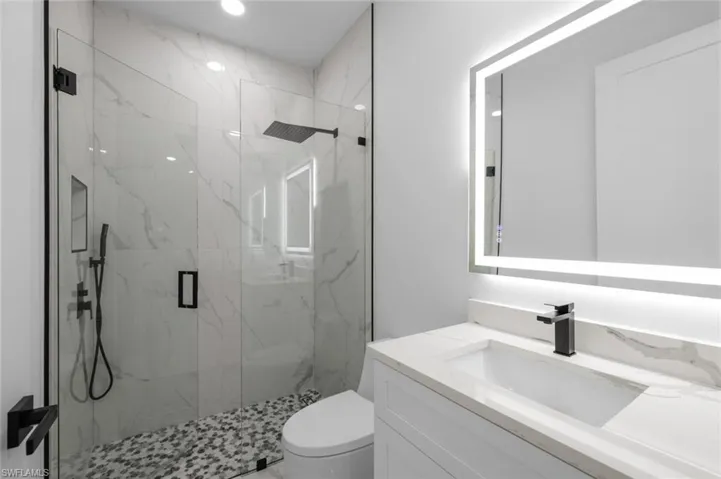 Bathroom with walk in shower, toilet, and vanity
