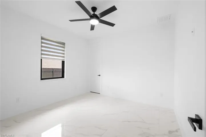 Unfurnished room with light tile patterned floors and ceiling fan