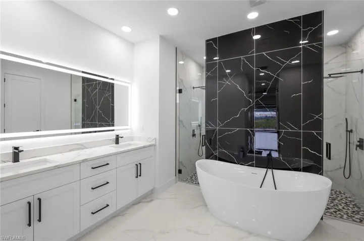 Bathroom featuring double vanity, tile patterned flooring, and independent shower and bath