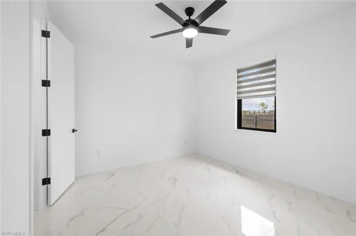 Tiled empty room featuring ceiling fan