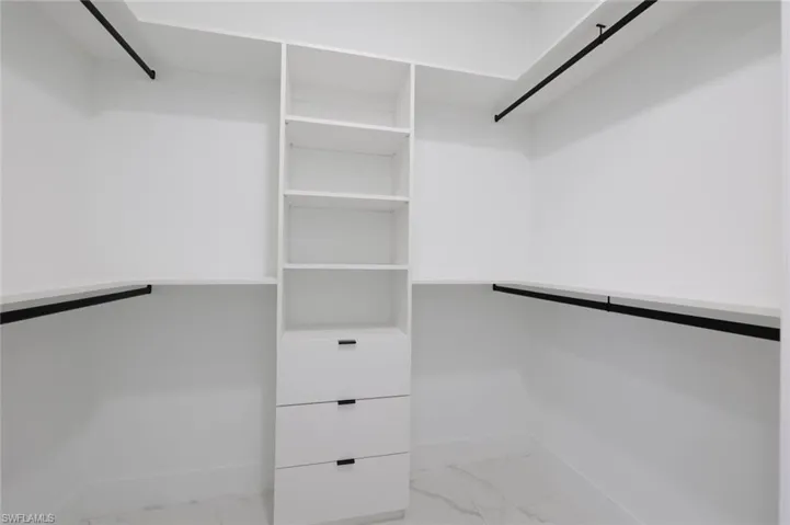Spacious closet with light tile patterned floors