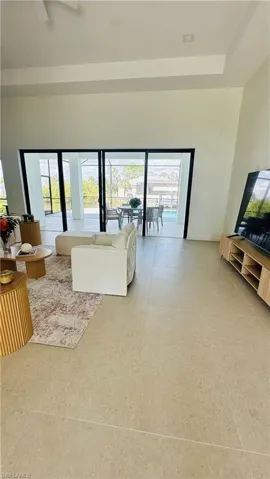 Spacious interior featuring neutral tile flooring and soaring ceilings