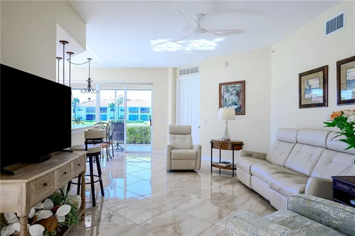 Family room area featuring light porcelain floors and modern ceiling fan
